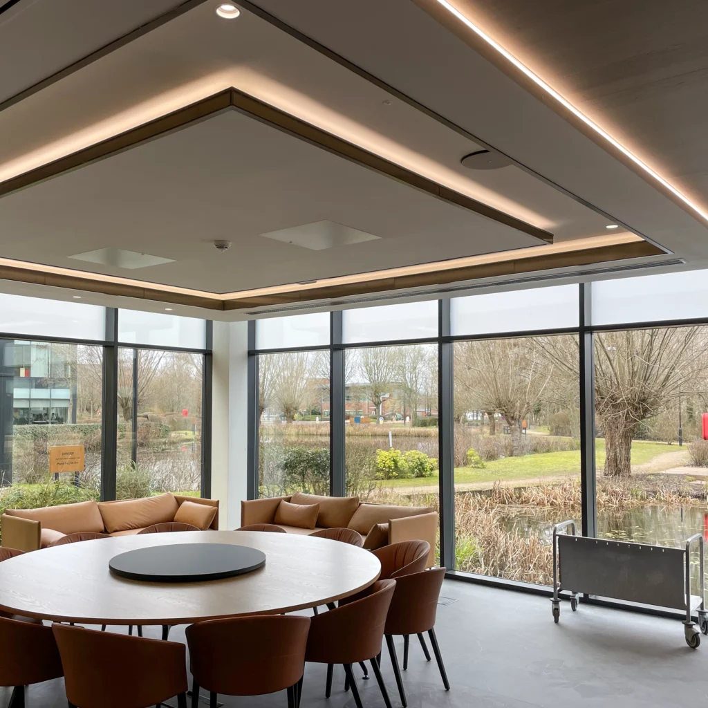 Finished meeting room fit-out with multi-level ceiling, shadow gap lighting, glazed partition and TV recess